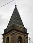 Rainbow-style pattern of coloured tiles on a church spire