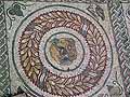 Lion's head mosaic in a laurel wreath